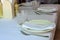 Table setting. Restaurant interior. Clean plates, glasses and cutlery on a white tablecloth. Preparing for guest service