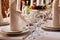 Table setting in the restaurant. Plates, glasses, forks and knives, napkins on the tablecloth on the table.