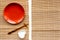 Table setting for sushi roll. Empty plate near chopstick and bowl for sause on mat background top view copyspace