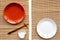 Table setting for sushi roll. Empty plate near chopstick and bowl for sause on mat background top view copyspace