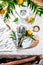 Table setting with white plate, cutlery, linen napkin and orange tree branch decoration on white linen tablecloth