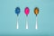 Table spoons filled with assortment of various colourful pills on blue pastel coloured background. Medication.