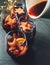 Table still-life with pouring Mulled wine with spices, fruits, cinnamon in thin glass mugs with Xmas tree garland lights on