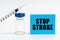 On the table is a syringe, an injection and a blue sign with the inscription - STOP STROKE