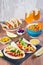 Table with tacos, mango salsa, nachos with sauce, guacamole, lemon beer for Cinco de Mayo celebration party. Appetizers and