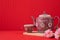 Table with Teapot and sakura flower on red background, Chinese new year background