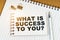 On the table there is a pen, clamps and a notebook with the inscription - WHAT IS SUCCESS TO YOU