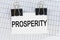 On the table there are reports and a business card with the inscription - PROSPERITY