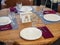 A table with three cutlery standing on striped napkins and one device without it. Table setting for four persons