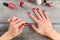 Table top view on young woman hands, applying second coat of red