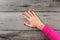 Table top view on young woman right hand with dark red nails on