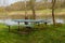 A table and two benches made of wood on the river bank