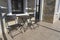 Table and two chairs in the courtyard in front of the entrance to the house