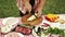 Table with vegetables and meat. Barbecue preparation. Man cutting zucchini on cutting board for grilling. Outdoor