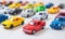 The table was covered with a colorful array of toy cars, creating a miniature traffic jam