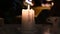 On the table a white large candle burns slowly close-up video 4k