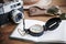 Table whith notebook, vintage camera, compass, sunglasses and hat.