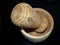 Table wooden mortar with pestle made from white acacia. Closeup. The product is placed in a mortar