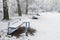 Tables and benches in the snow-covered city park.