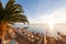 Tables in cafe. Summer sunrise on coast, Corfu island, Greece. Beach with Sunbeds and umbrellas with perfect views of