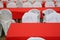 Tables covered with red tablecloths and chairs in white covers.