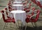 Tables and red chairs in an alfresco cafe