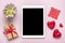 Tablet for chooses gifts, makes purchase, envelope, box, two red hearts on pink table Top view Flat lay Holiday shopping list, Hap