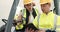 Tablet, collaboration and a construction worker in a forklift talking to a colleague about project management on a