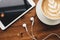 Tablet, headphones and cappuccino with latte art