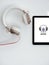 Tablet with icon for audiobook and headphones on white background. Overhead shot