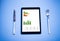 Tablet, knife, fork, and food with graphic colors