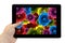 Tablet PC in hand with mix collage of rose flowers rainbow background on screen isolated