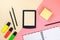 Tablet, school supplies, notebook and colored markers on pastel pink and beige background.