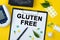 Tablet with text GLUTEN FREE. Nearby is a tonometer, medicines, vitamins and a pen