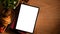 Tablet touchpad blank screen mockup and copy space on wooden background