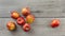 Tabletop view, 7 red glossy apples on gray wooden desk.