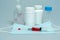 tablets in jars, antiseptic gel, disposable mask, syringe with a red vaccine