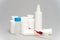 tablets in jars, antiseptic gel, disposable mask, syringe with a red vaccine.