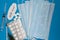 Tablets syringes and ampoules and a protective medical mask on a blue background with medicines. The new coronavirus 2019-cov