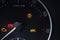 Tachometer dial with needle showing zero rpm with diagnostic icons isolated on black background.