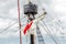 Tackles of an old sailing vessel - a mast, a mast, raised red-white sails, ropes.