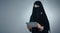 Tackling personal and professional tasks with digital tech. Studio shot of a young woman wearing a burqa and using a