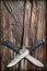 Tactical Combat Hunting Survival Bowie Knives With Crossed Blades On Grunge Vignetted Old Battered Grooved Wood Background