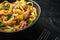 Tagliatelle with chanterelles and stewed rabbit, in bowl, on black stone background