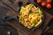 Tagliatelle with chanterelles and stewed rabbit, in frying cast iron pan or pot, on old dark  wooden table , top view flat lay