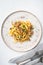 Tagliatelle with chanterelles and stewed rabbit, on plate, on white stone  background, top view flat lay