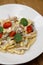 Tagliatelle with mushrooms  parmesan and thyme and dried cherry tomatoes. Restaurant dish close-up