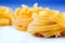 Tagliatelle pasta on white blue background.Macro concept