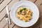 Tagliatelle vegetarian Pasta Dish with Mushrooms decorated with basil. Delicious lunch with pasta and white mushrooms