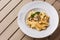 Tagliatelle vegetarian Pasta Dish with Mushrooms decorated with basil. Delicious lunch with pasta and white mushrooms